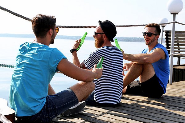 Freunde trinken Bier am Pier